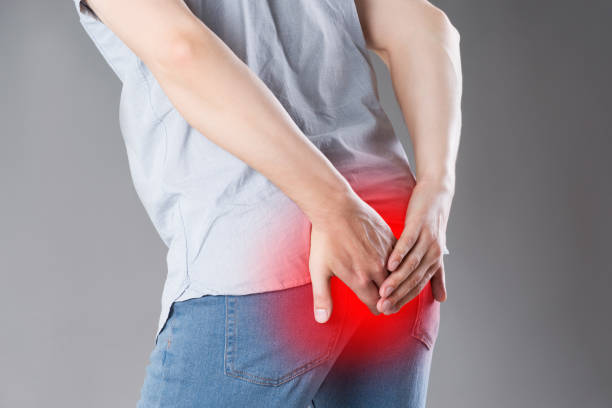 A man with a painful back pain seeking the best piles treatment in Kota.